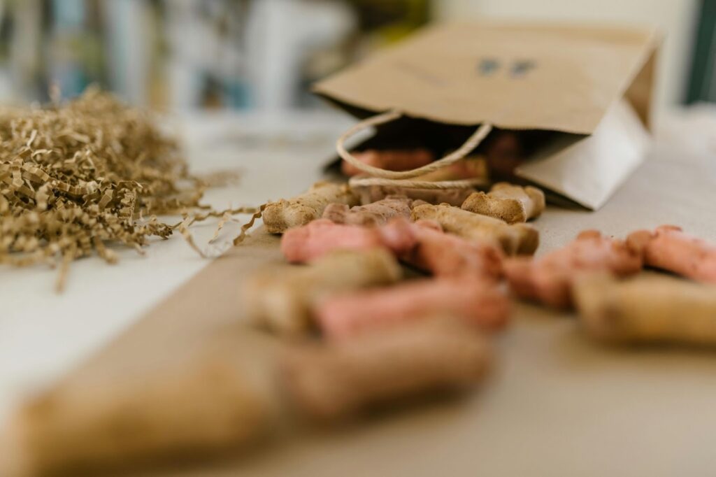 Picture of a close-up view of bone-shaped dog treats spilling out of a brown paper bag onto a surface